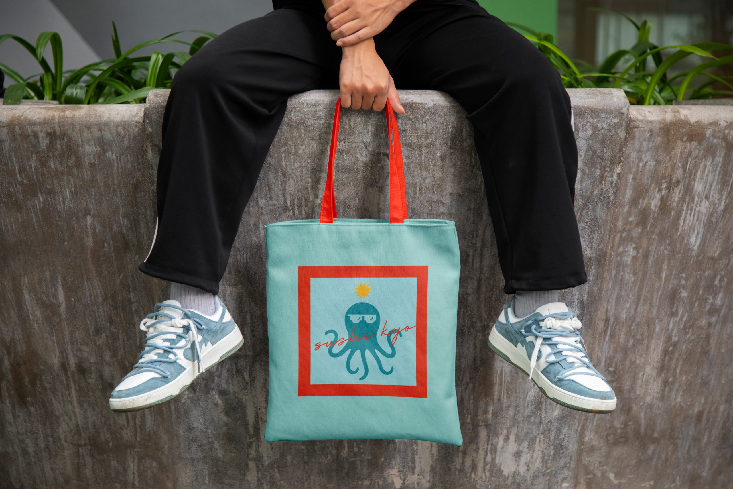 Sushi restaurant merchandise tote bag with bold branding and octopus logo