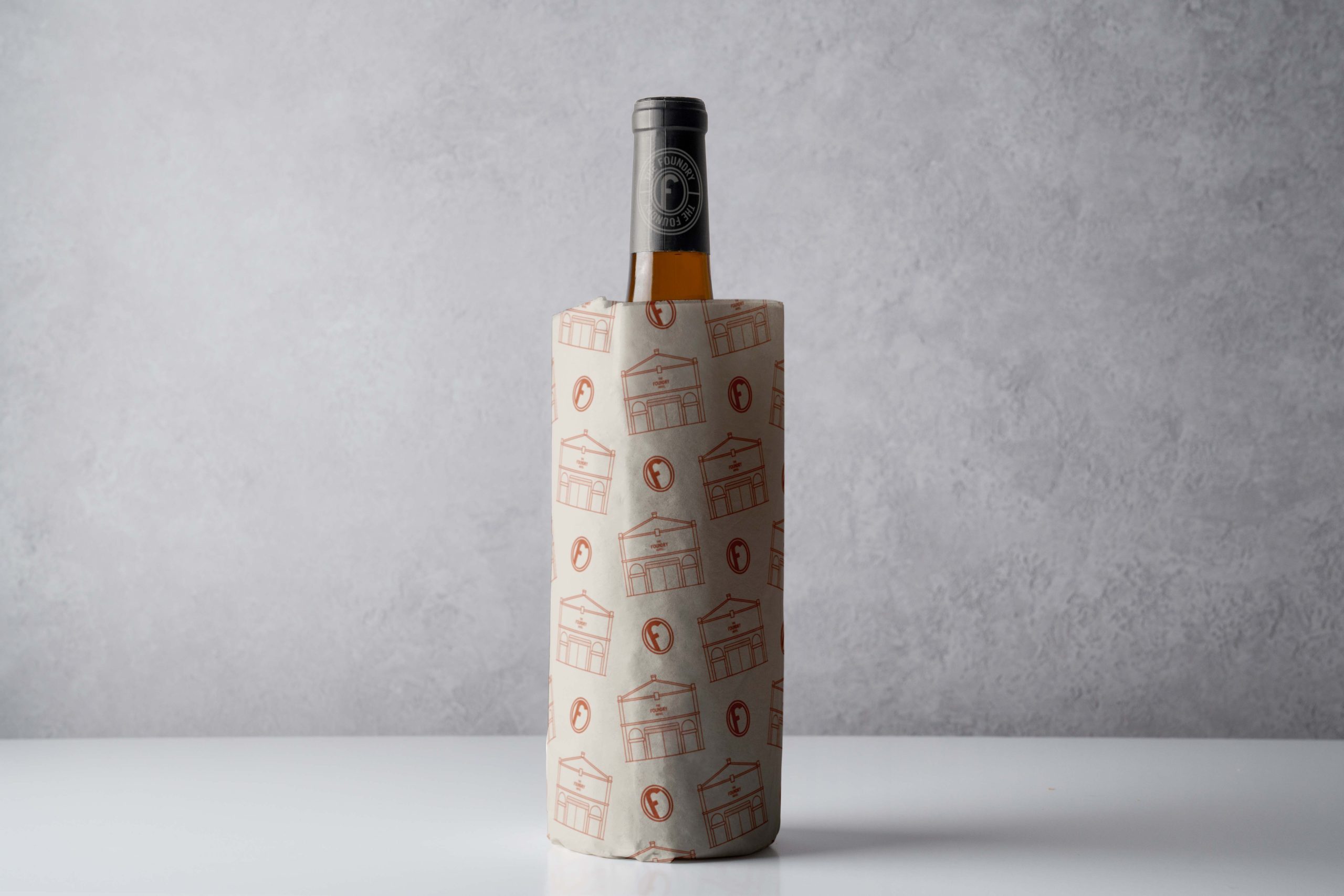 Wine bottle wrapped in custom branded packaging paper