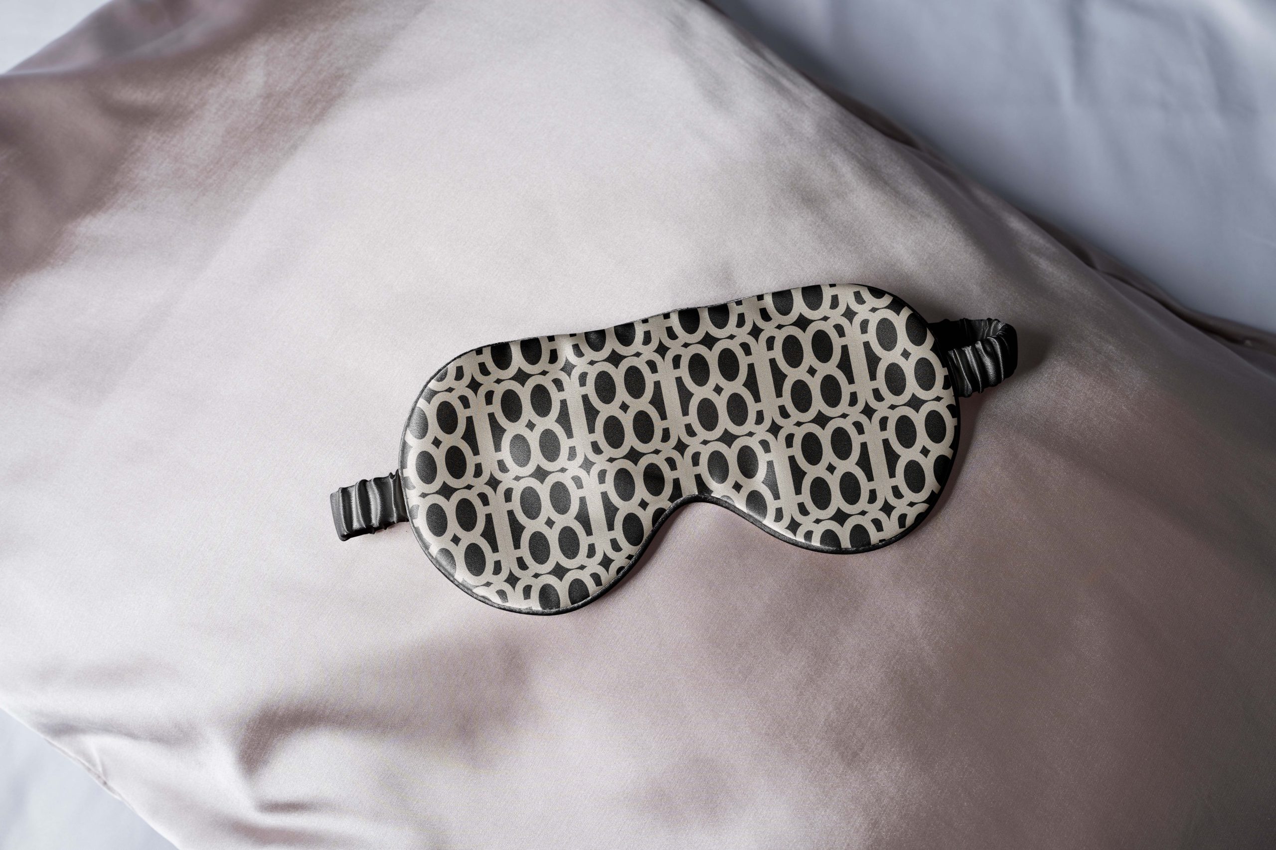 Patterned sleep mask displayed on a hotel pillow
