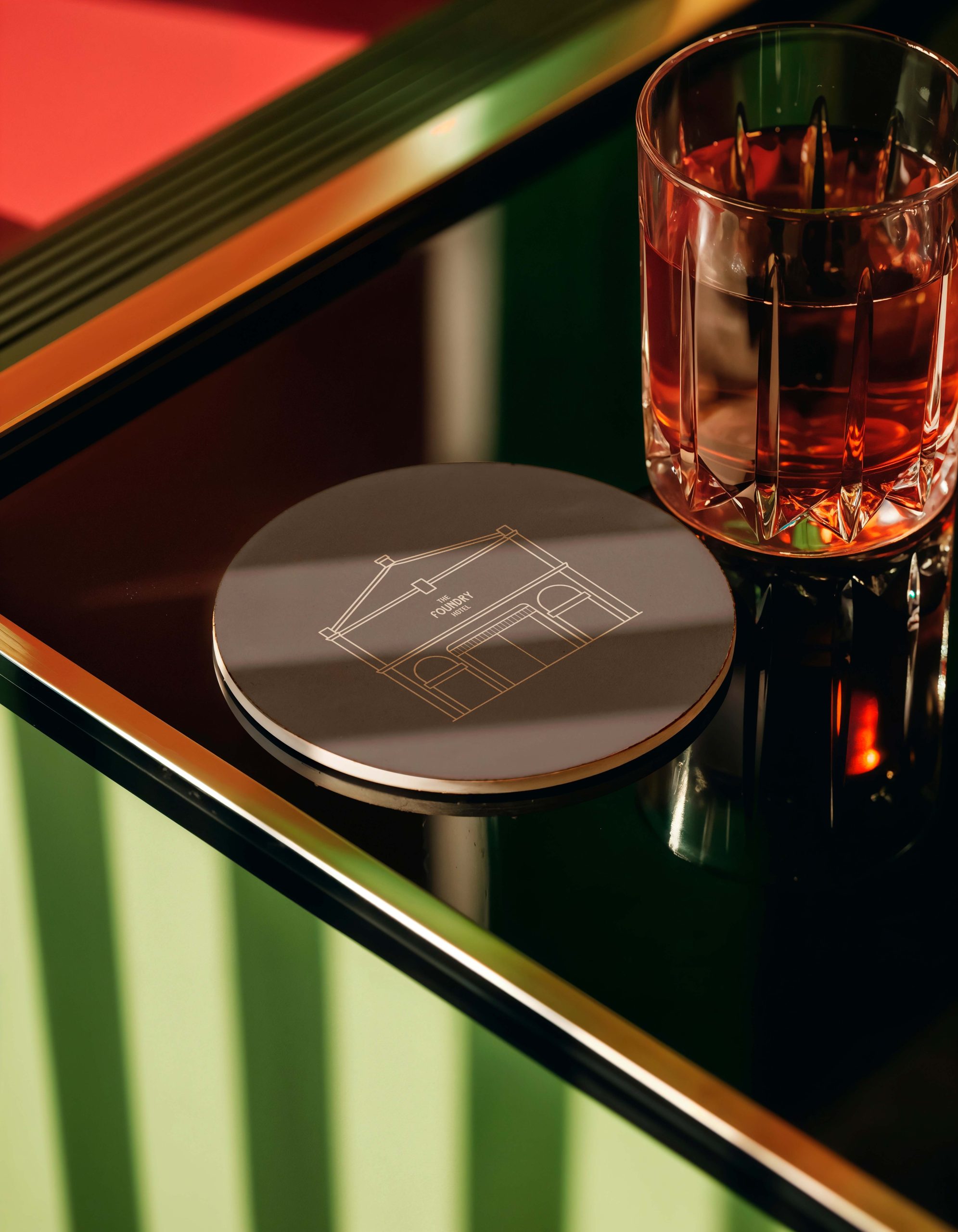 Branded hotel coaster and cocktail glass displayed on a bar counter