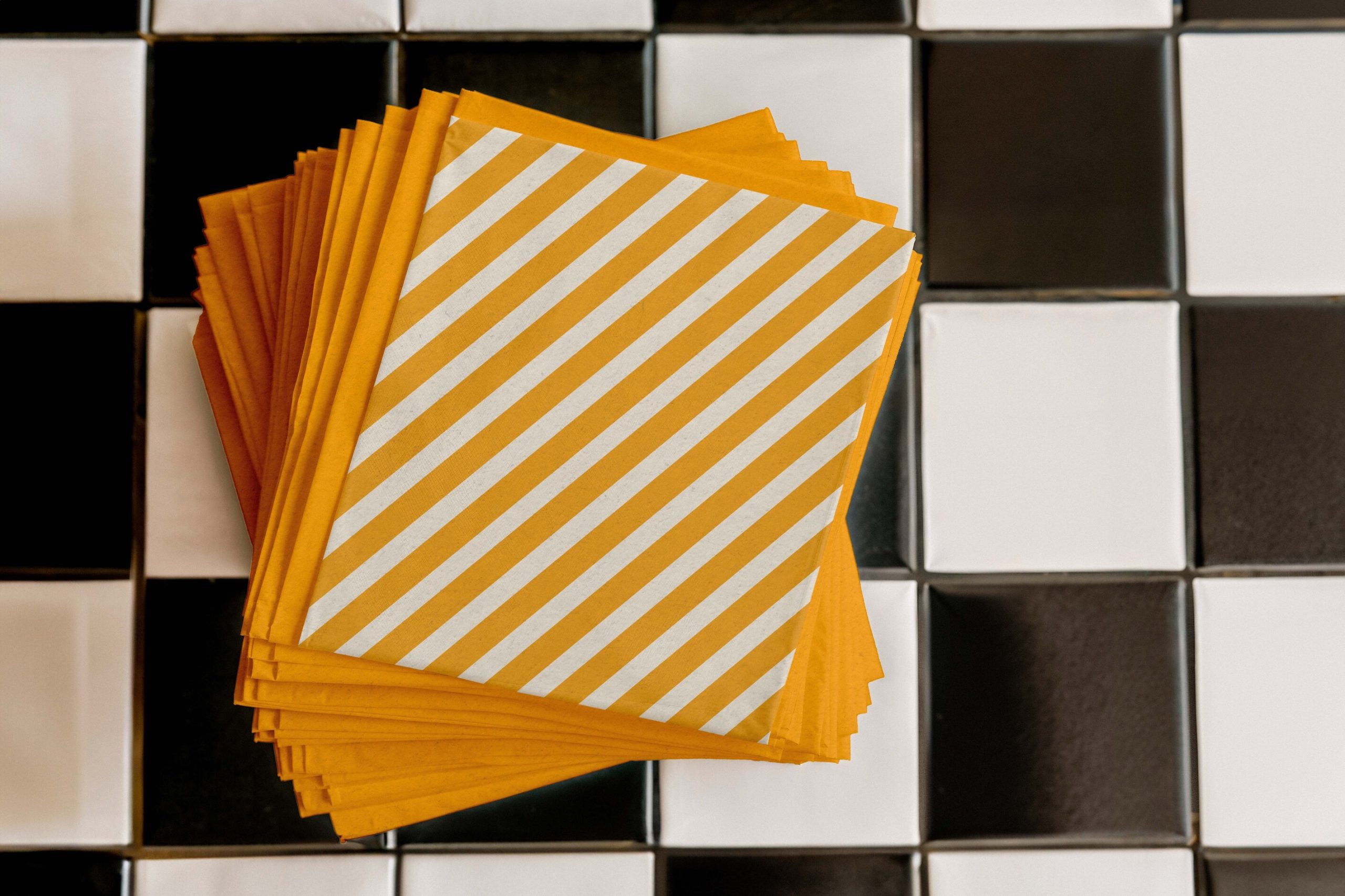 Leos Zapieksy branded yellow and white striped paper napkins