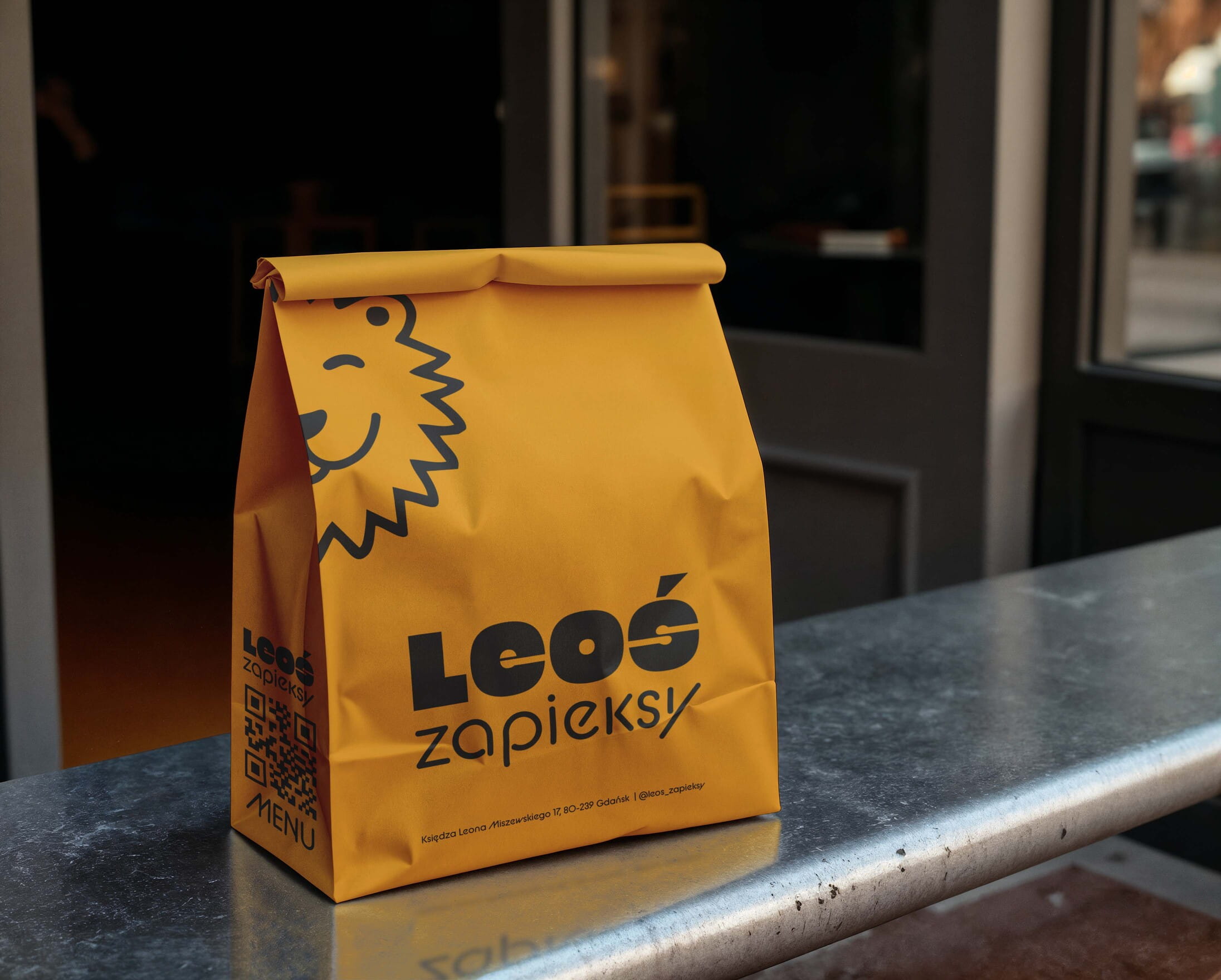 Leos Zapieksy yellow takeaway bag with custom logo and lion illustration