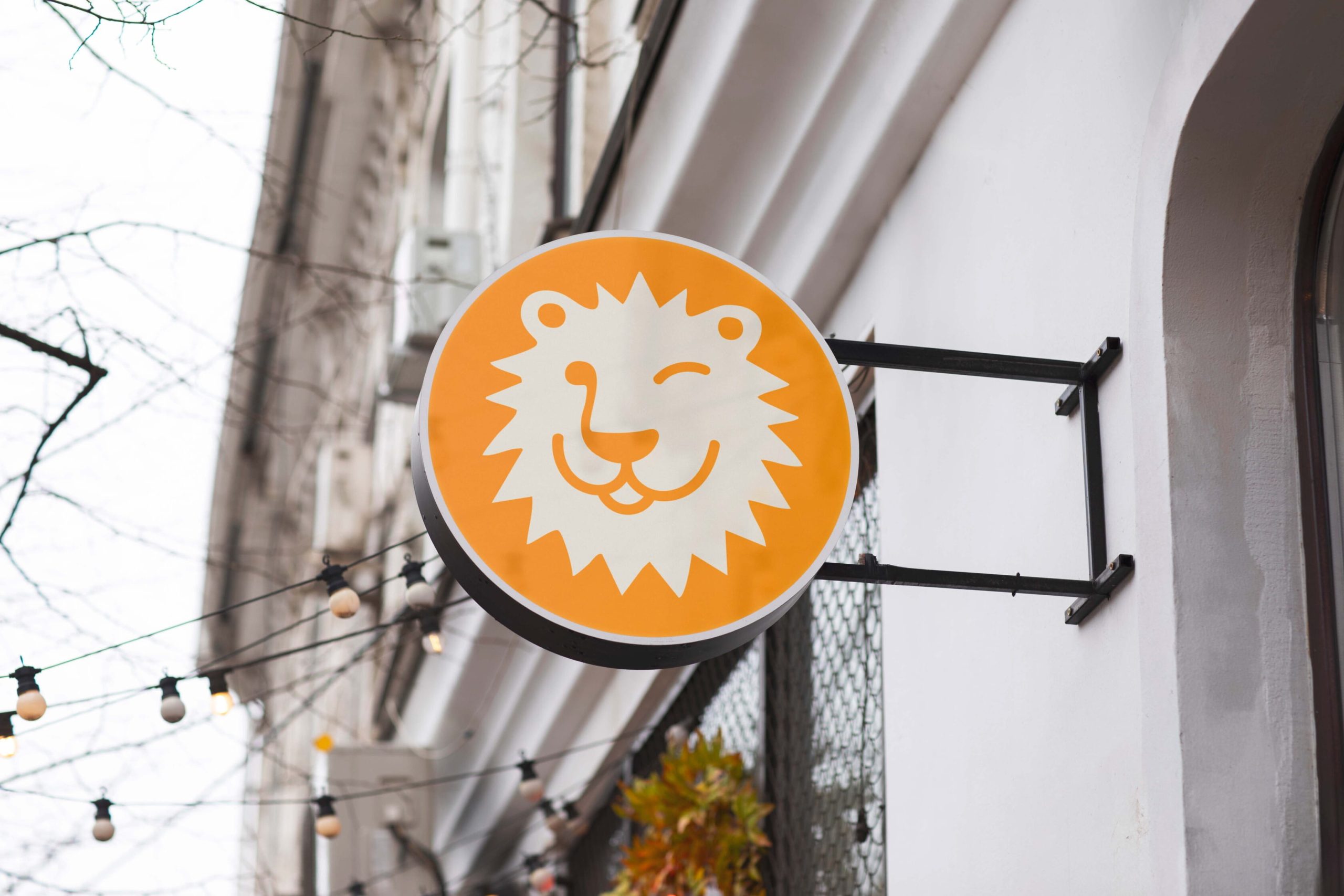 Leos Zapieksy illuminated lion logo on a round exterior restaurant sign